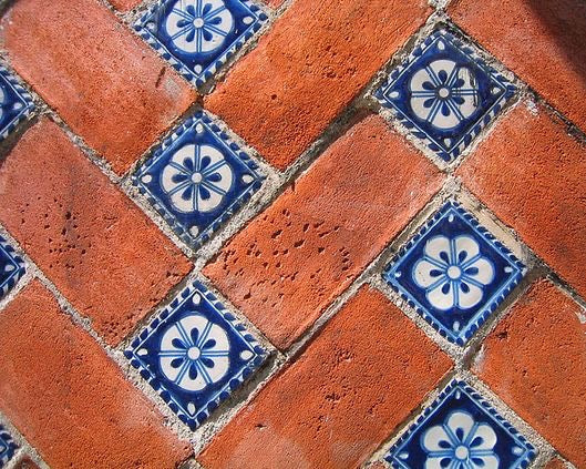 Pavimento de olambrillas sevillanas en villa de Grecia, colores renacentistas y composición mediterránea.